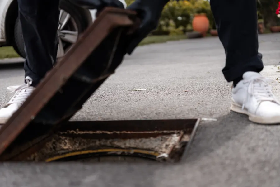 Ouverture d'un regard d'assainissement avant une inspection de canalisation