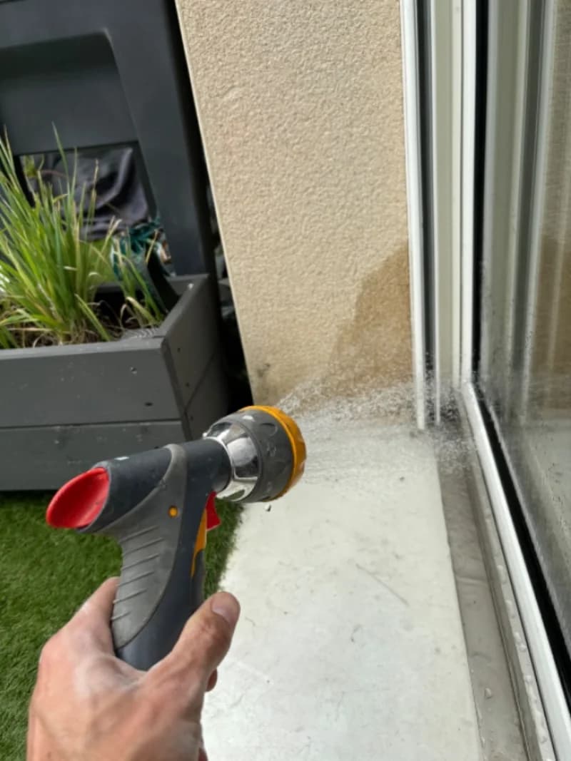 Test d'aspersion au jet sur une façade pour reproduire les conditions de pluie